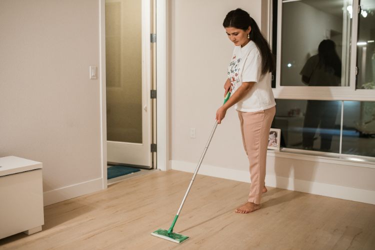 Woman mopping floor for an end of lease clean
